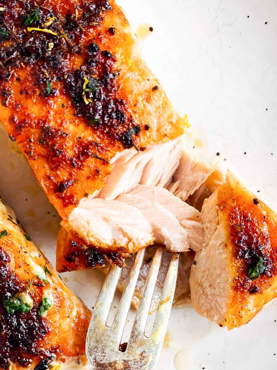 close up of flaked salmon on white plate