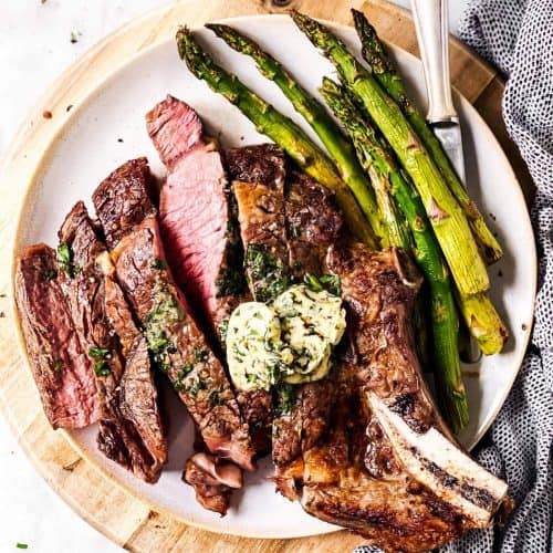 sliced steak on platter with asparagus