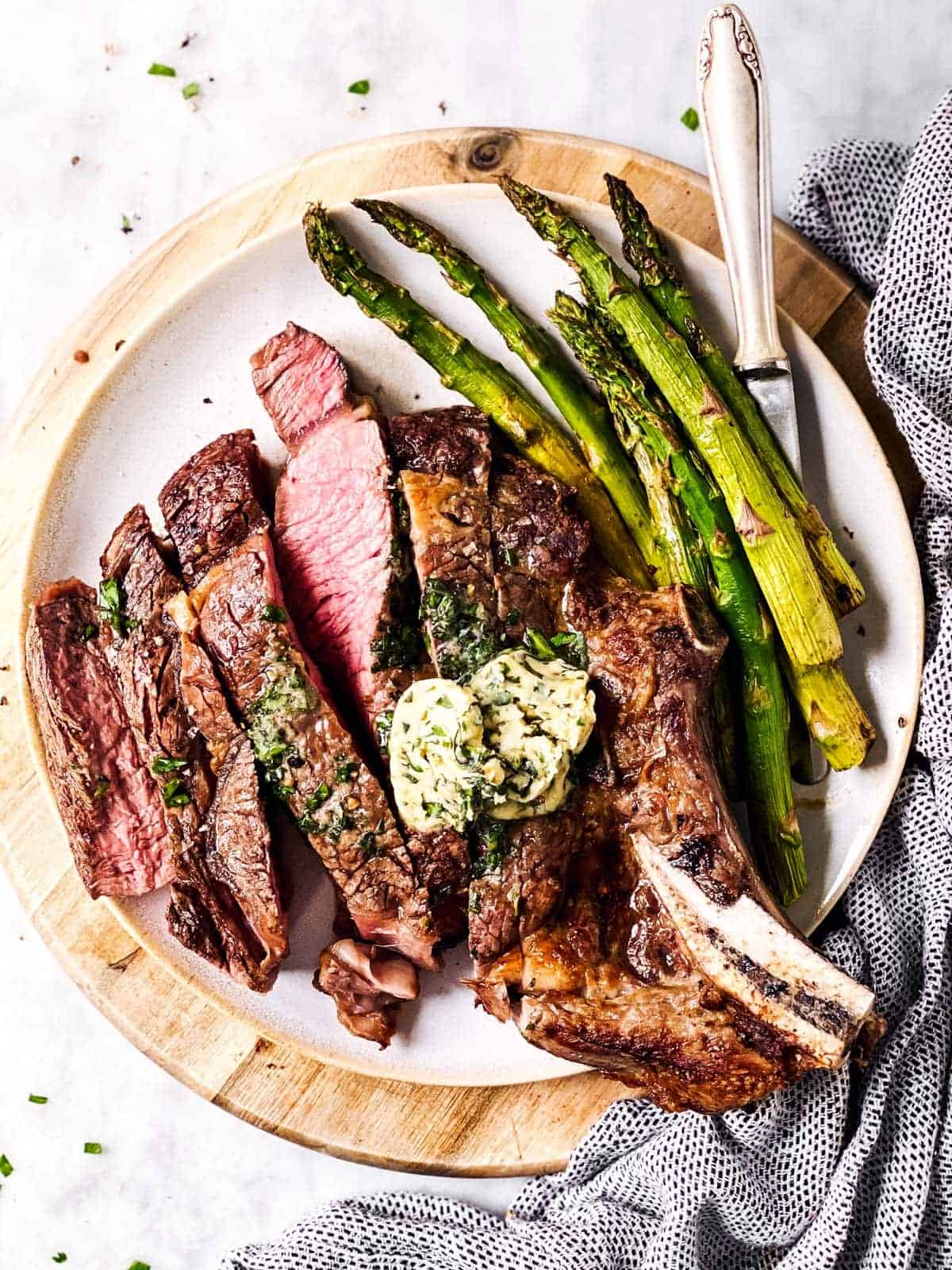 sliced steak on platter with asparagus