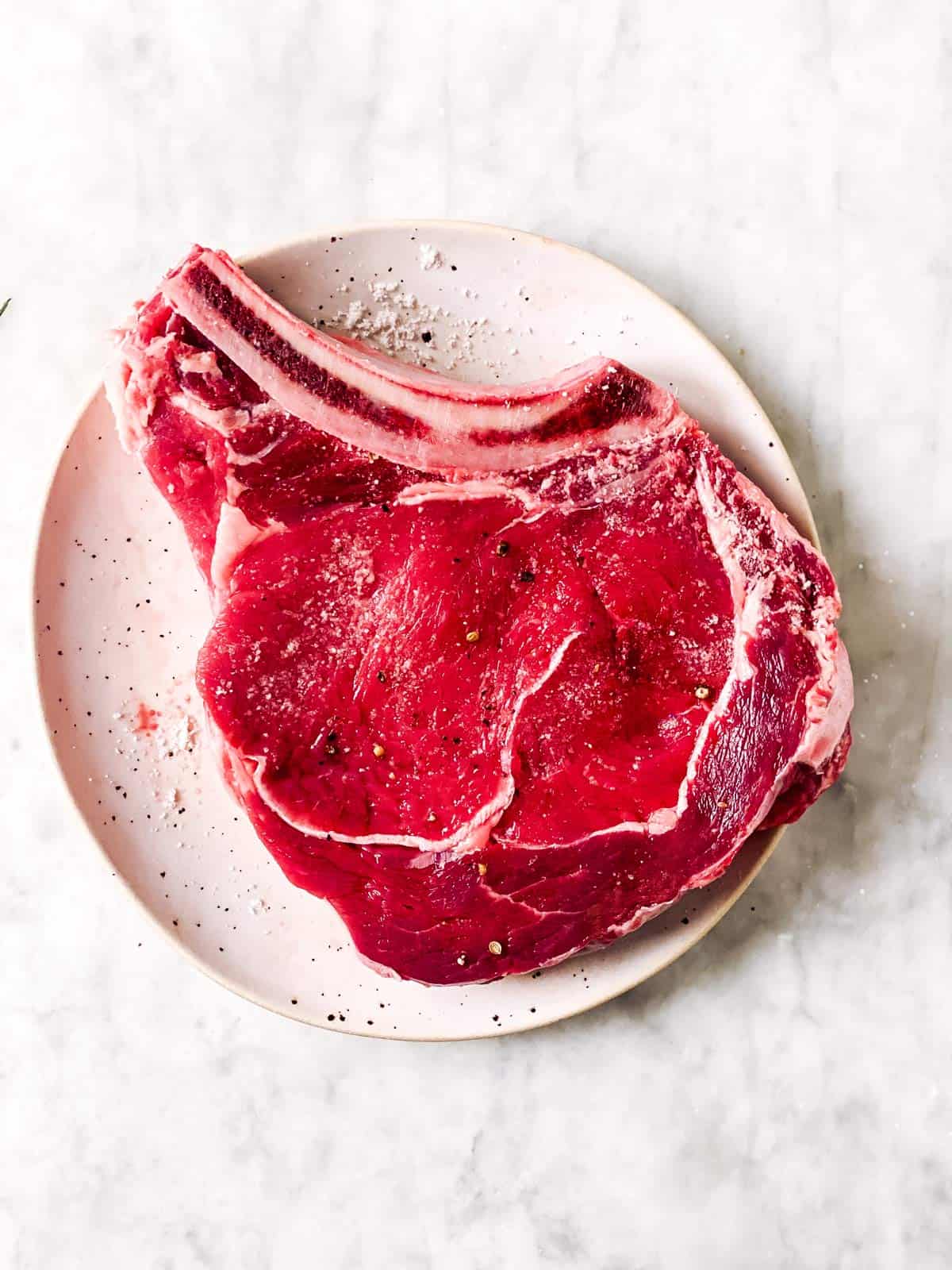 seasoned rib eye steak on white plate