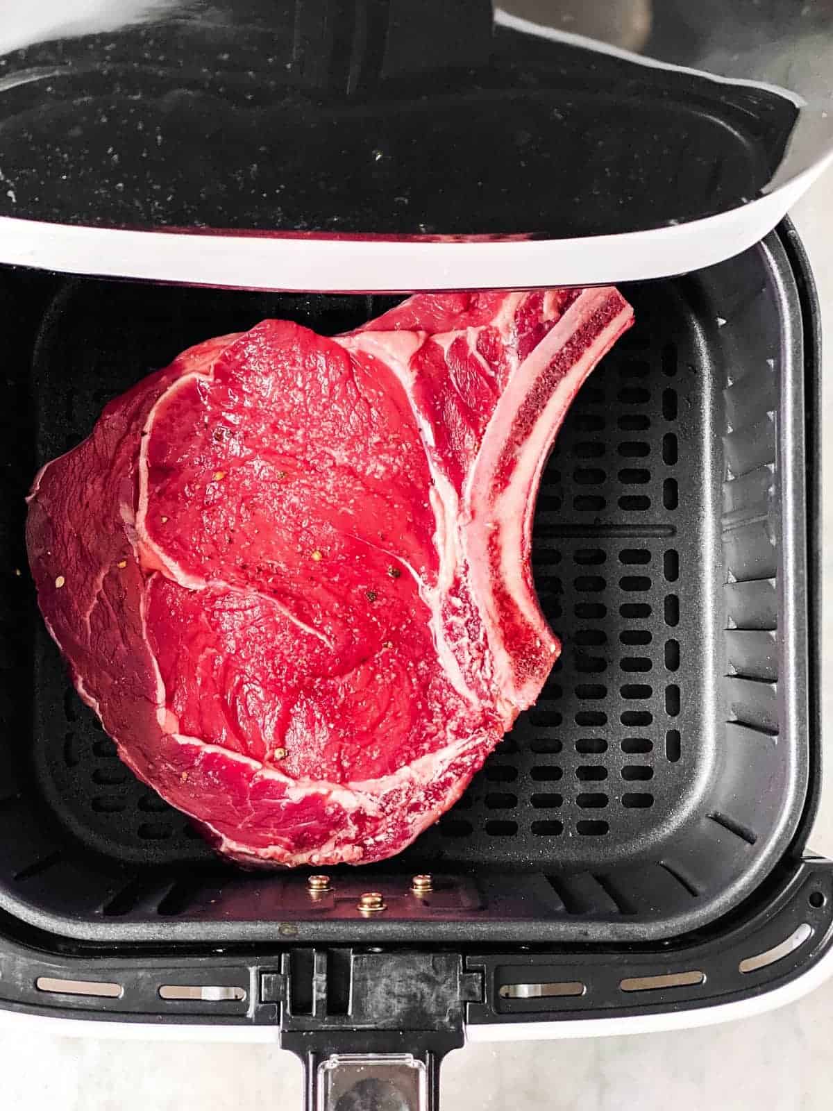 seasoned steak in air fryer basket