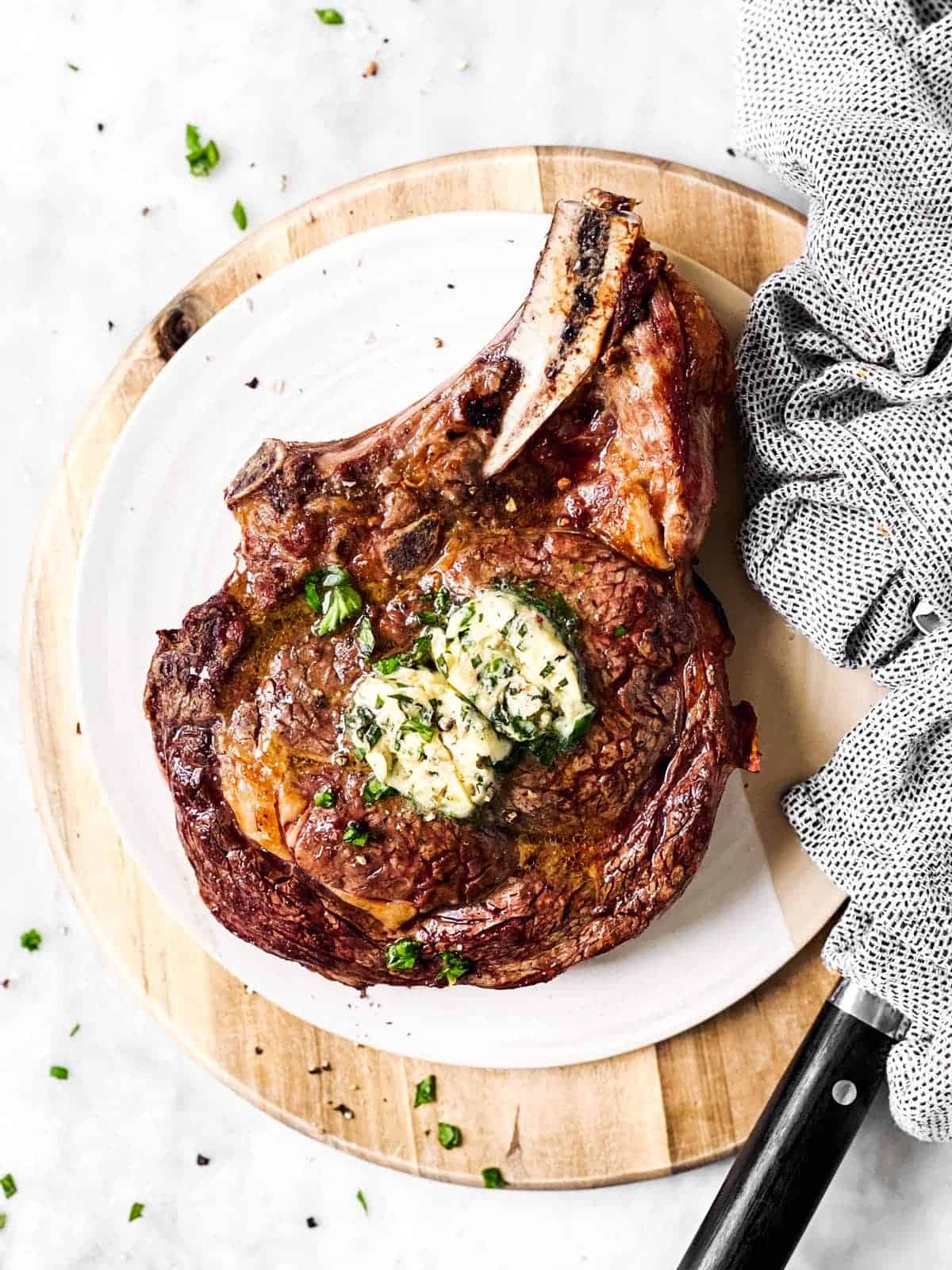 overhead view of cooked steak with garlic butter on platter