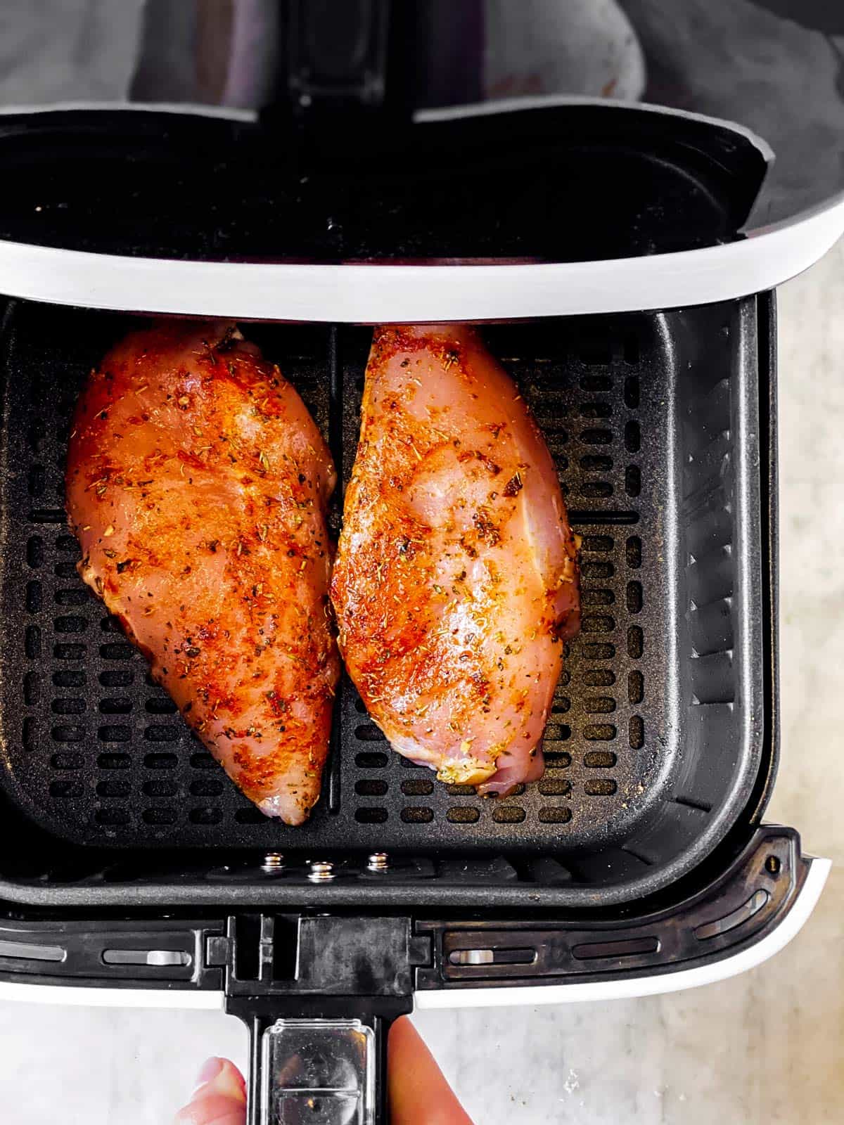 raw chicken breast in air fryer basket