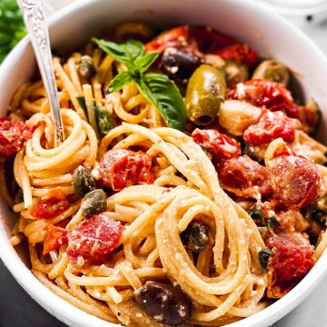 frontal view of white bowl filled with baked feta pasta