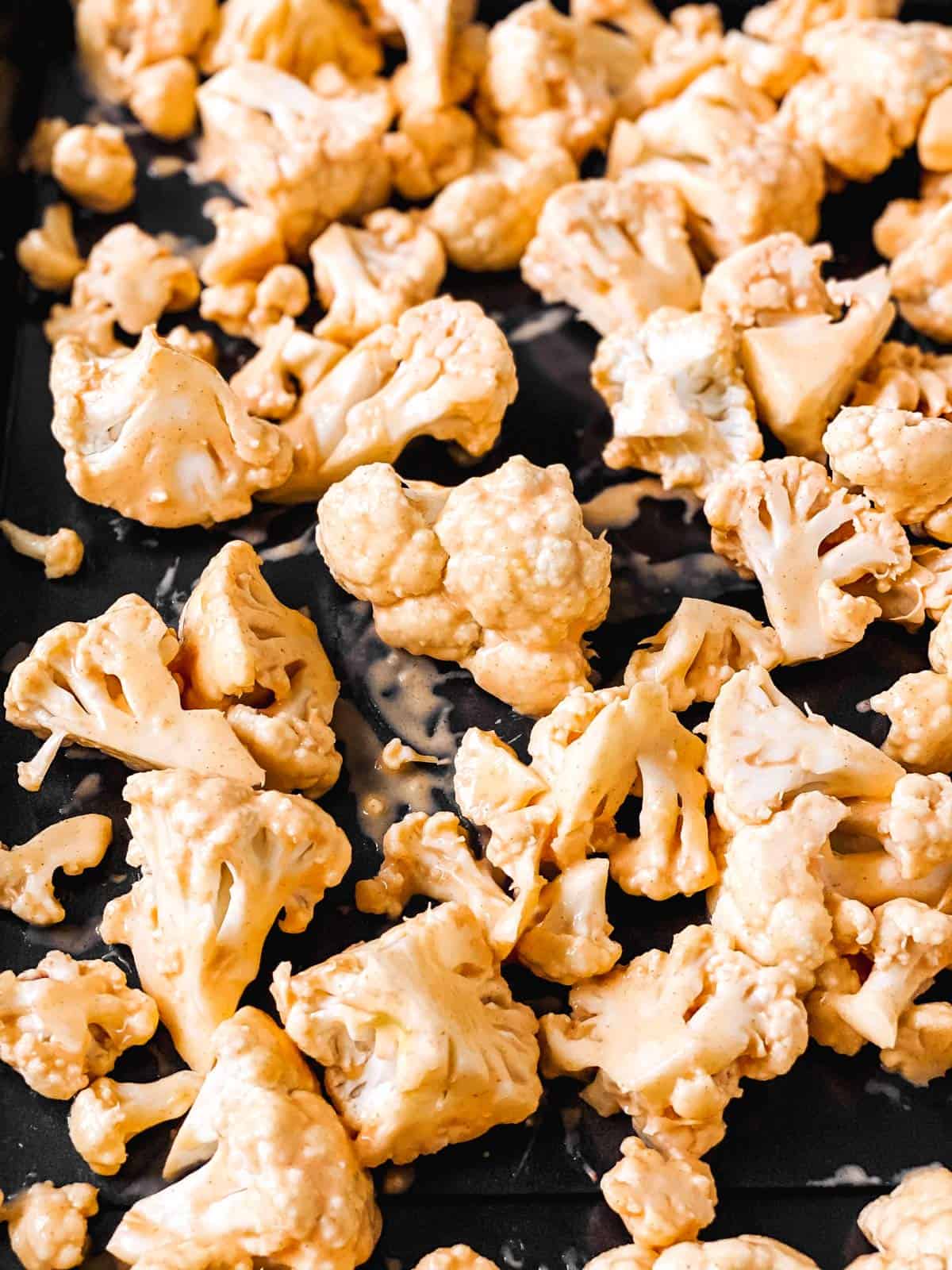 close up photo of battered cauliflower on sheet pan