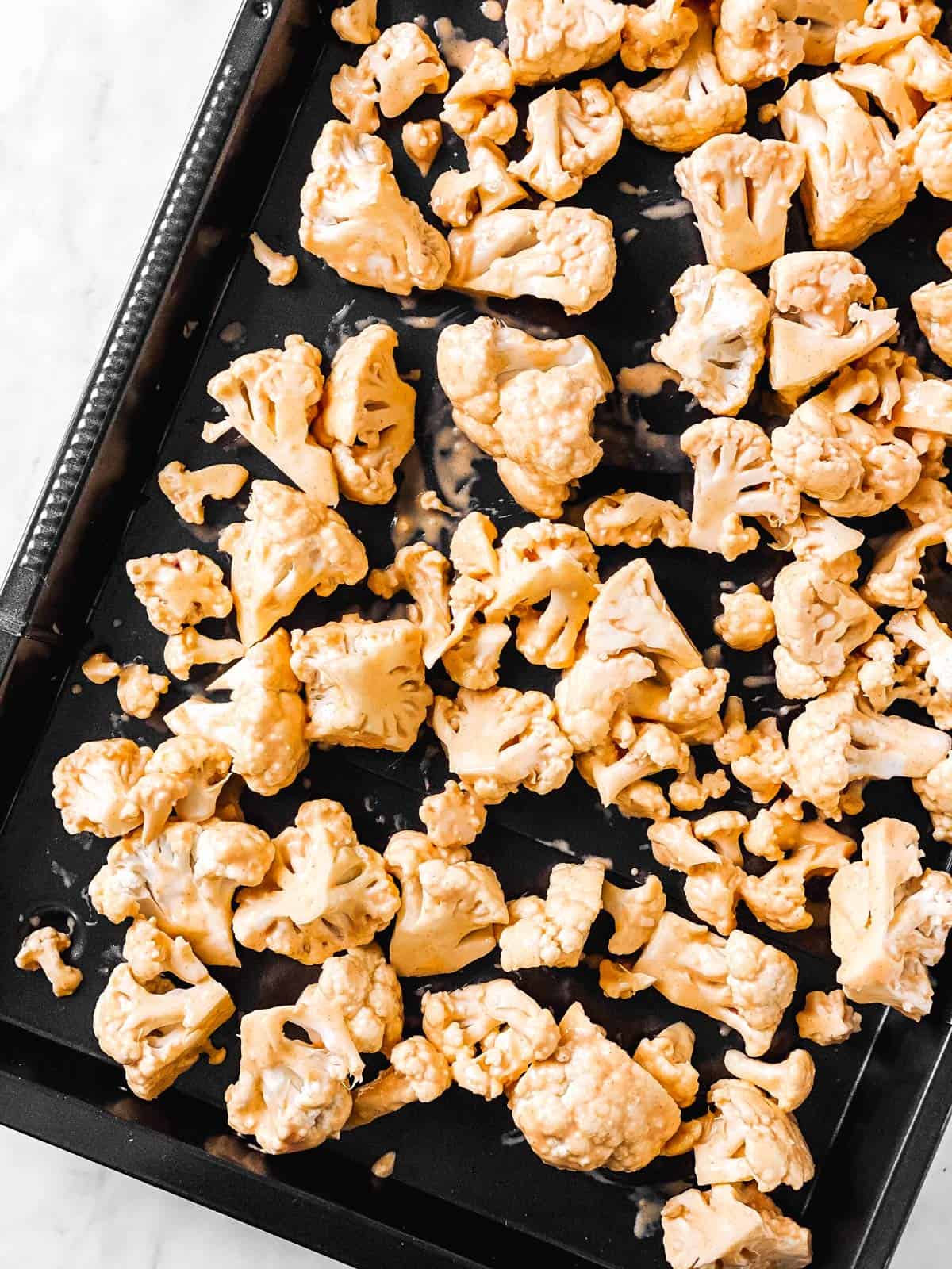 overhead view of battered cauliflower on sheet pan