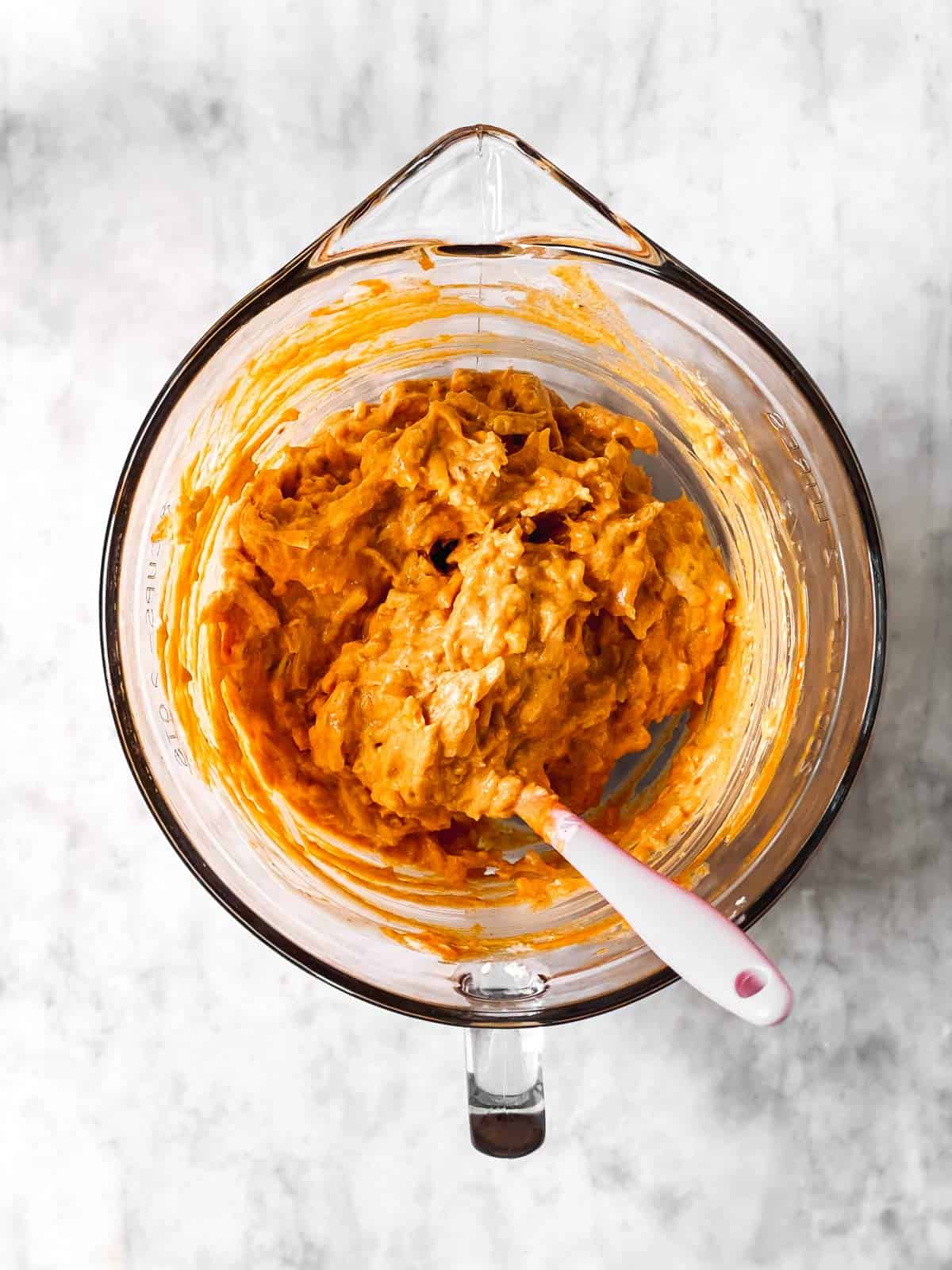 glass bowl with mixture for buffalo chicken dip