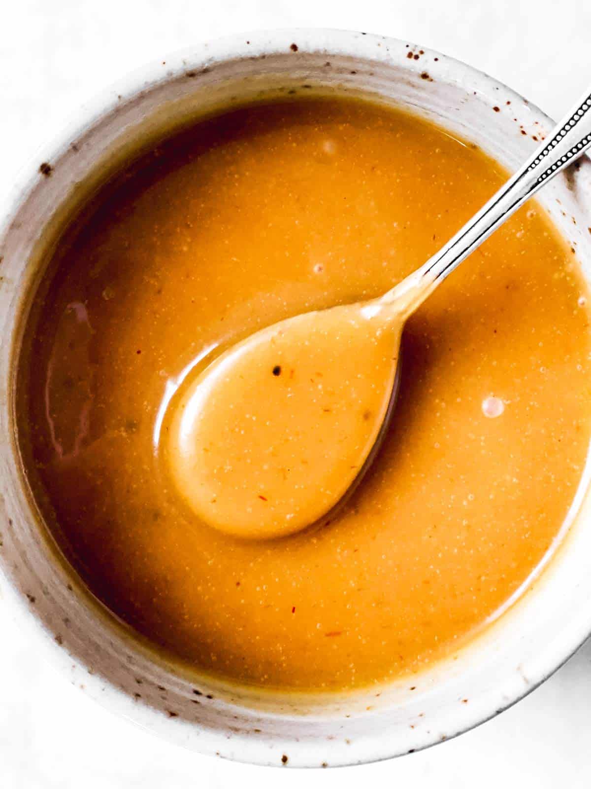 overhead view of white bowl with homemade chick oil a sauce