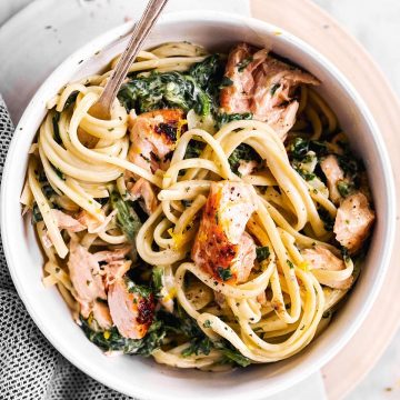 overhead view of white bowl with creamy salmon pasta