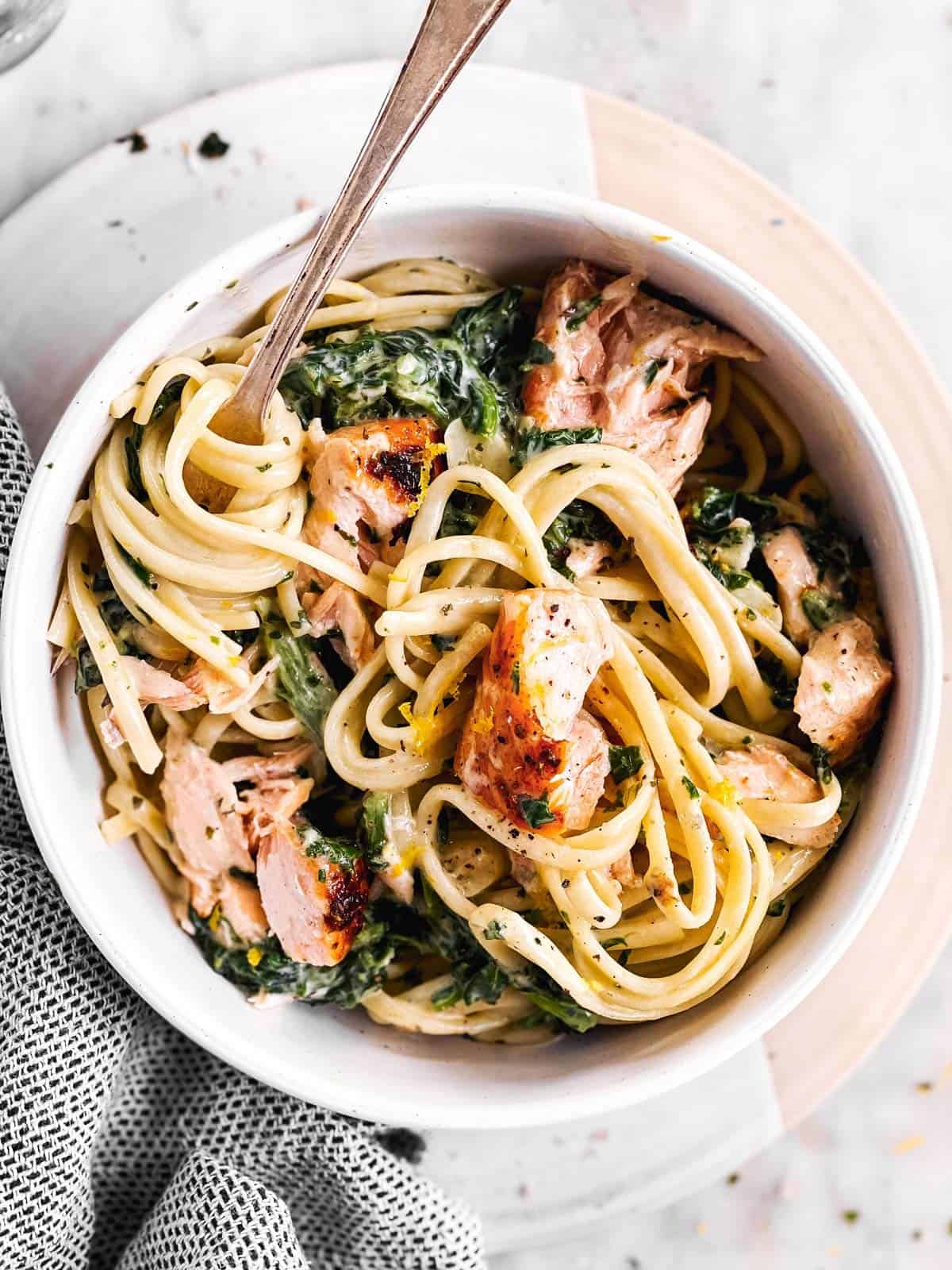 overhead view of white bowl with creamy salmon pasta