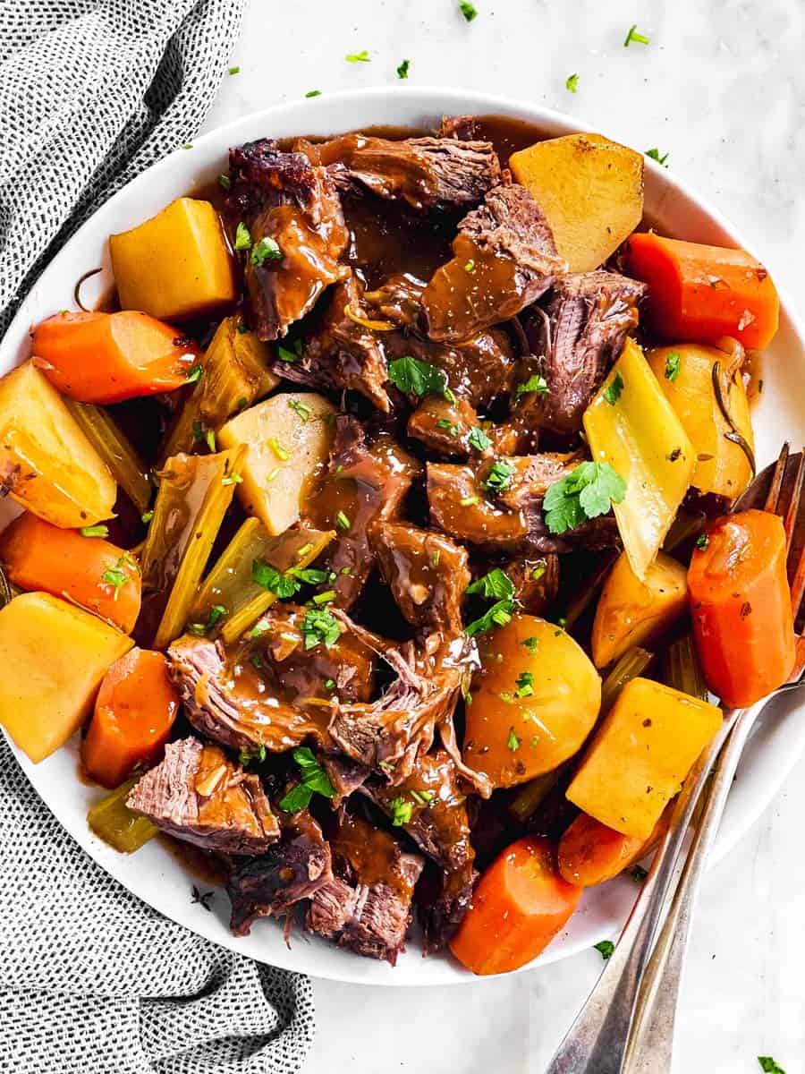 overhead view of white platter filled with pot roast