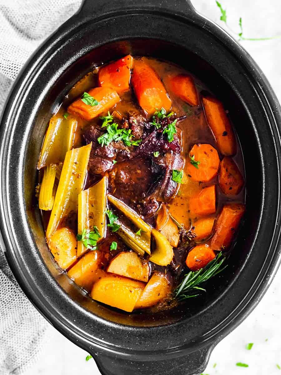 overhead view of black crock with cooked pot roast inside