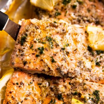 close up photo of baked salmon on lined pan