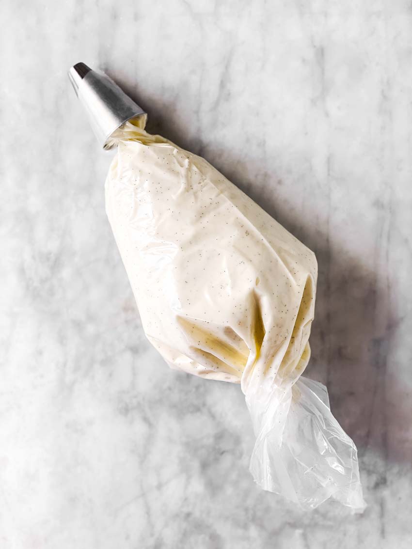 piping bag filled with vanilla bean cream cheese frosting