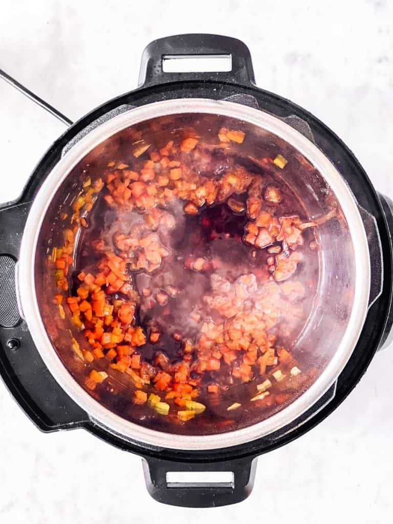 overhead view of instant pot with mirepoix and red wine