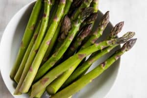 trimmed asparagus in white plate