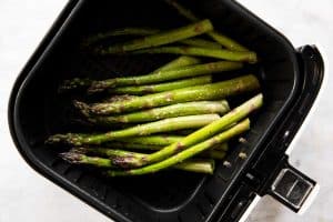 raw asparagus in air fryer basket