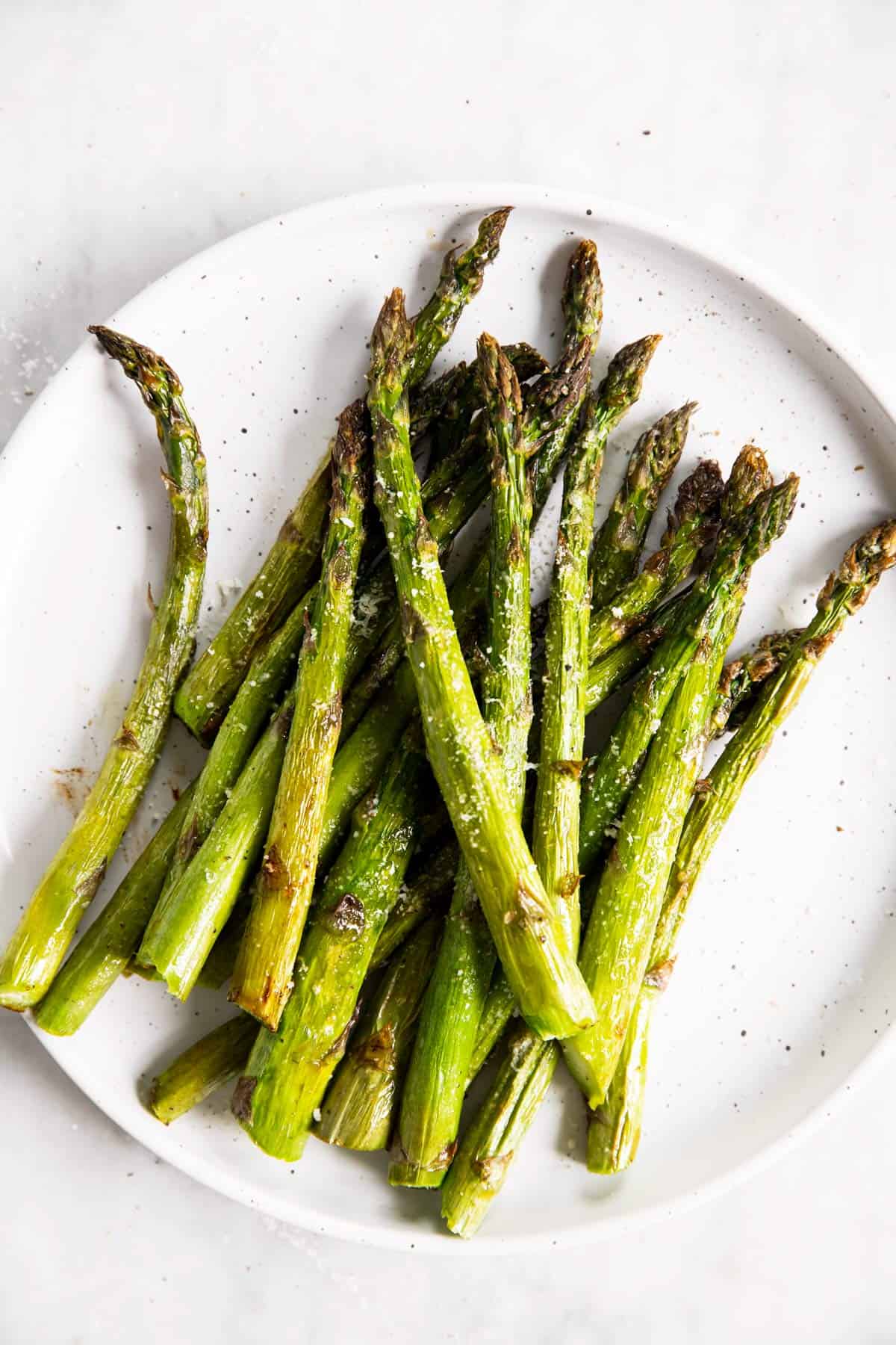 overhead view of air fried asparagus on white plate