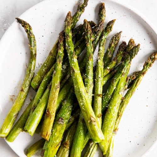 overhead view of air fried asparagus on white plate