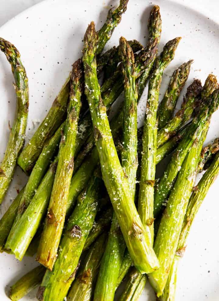 overhead view of air fried asparagus on white plate