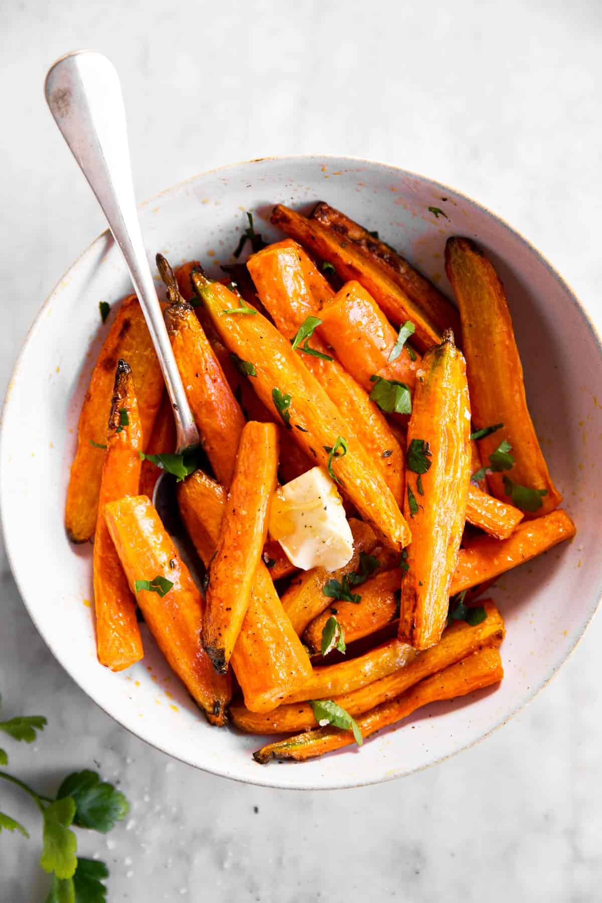 white bowl with air fried carrots and parsley