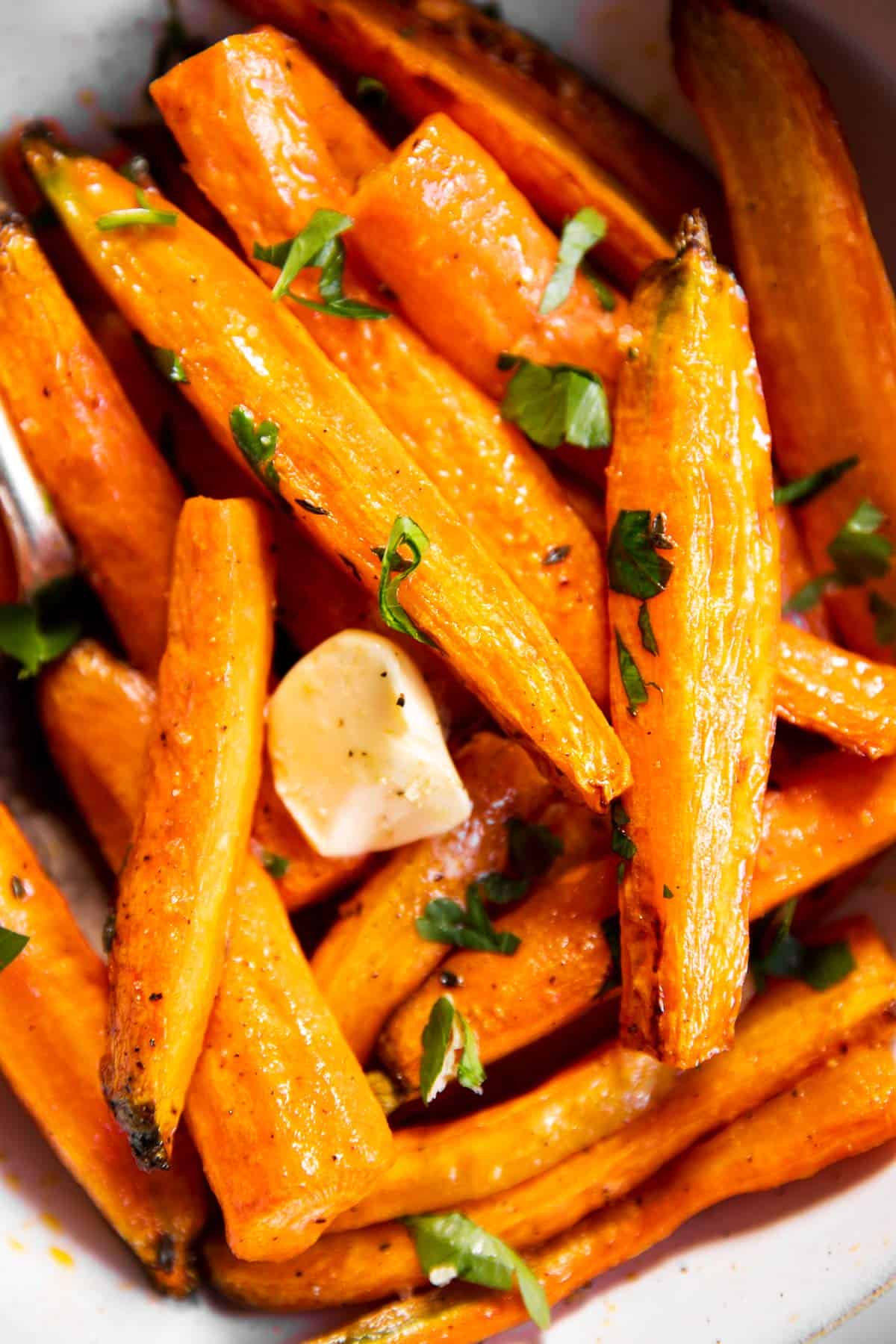 close up photo of air fryer carrots in bowl with butter