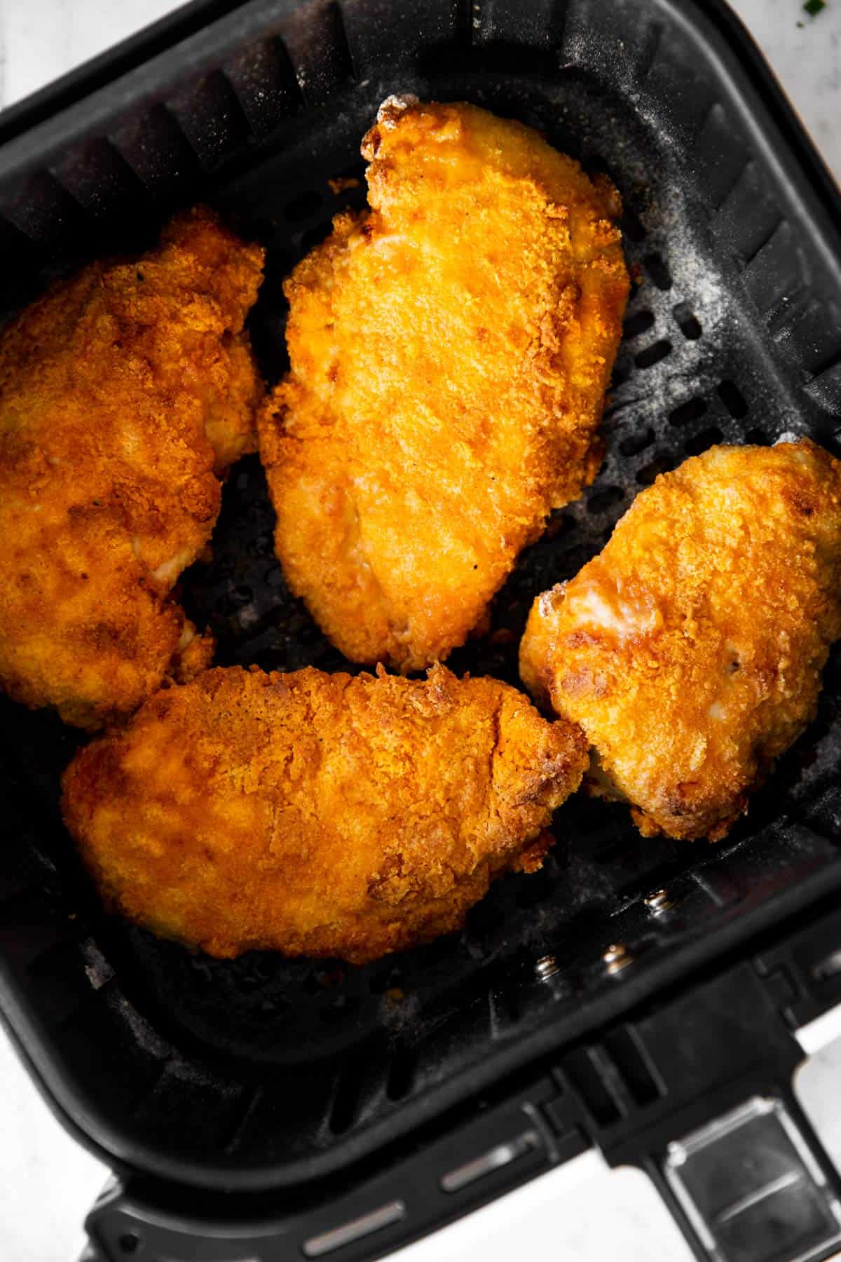 overhead view of fried chicken in air fryer basket