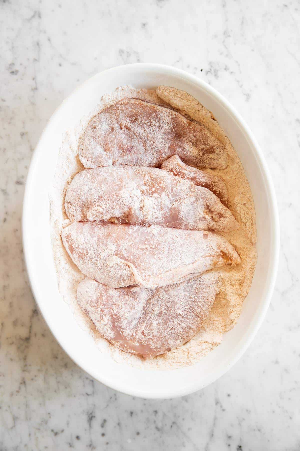 floured chicken in baking dish