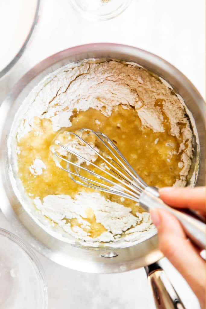 whisking flour with melted butter in saucepan