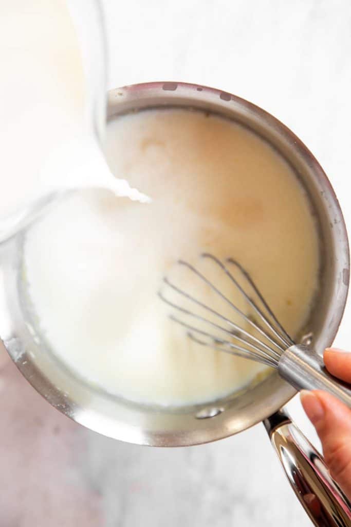 pouring milk into saucepan