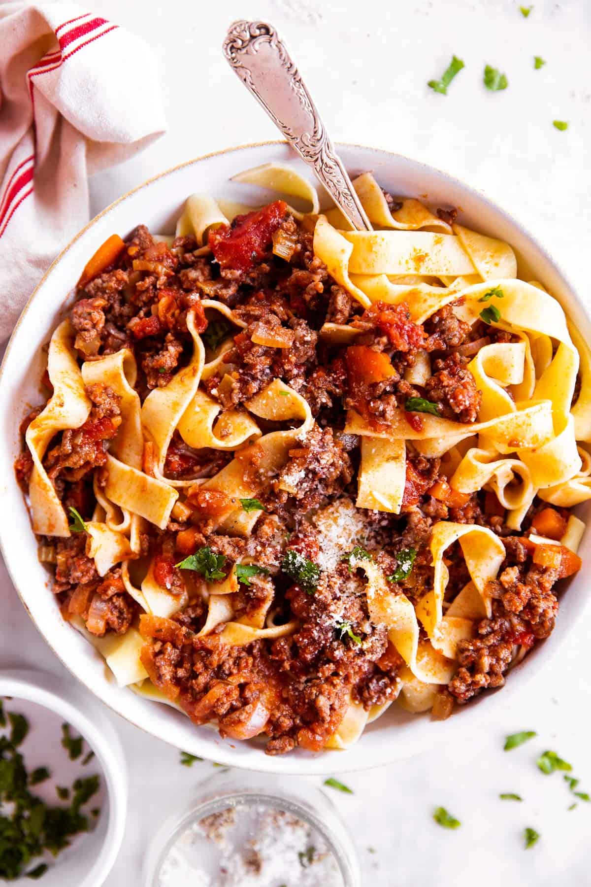 overhead view of pappardelle with bolognese sauce in white bowl