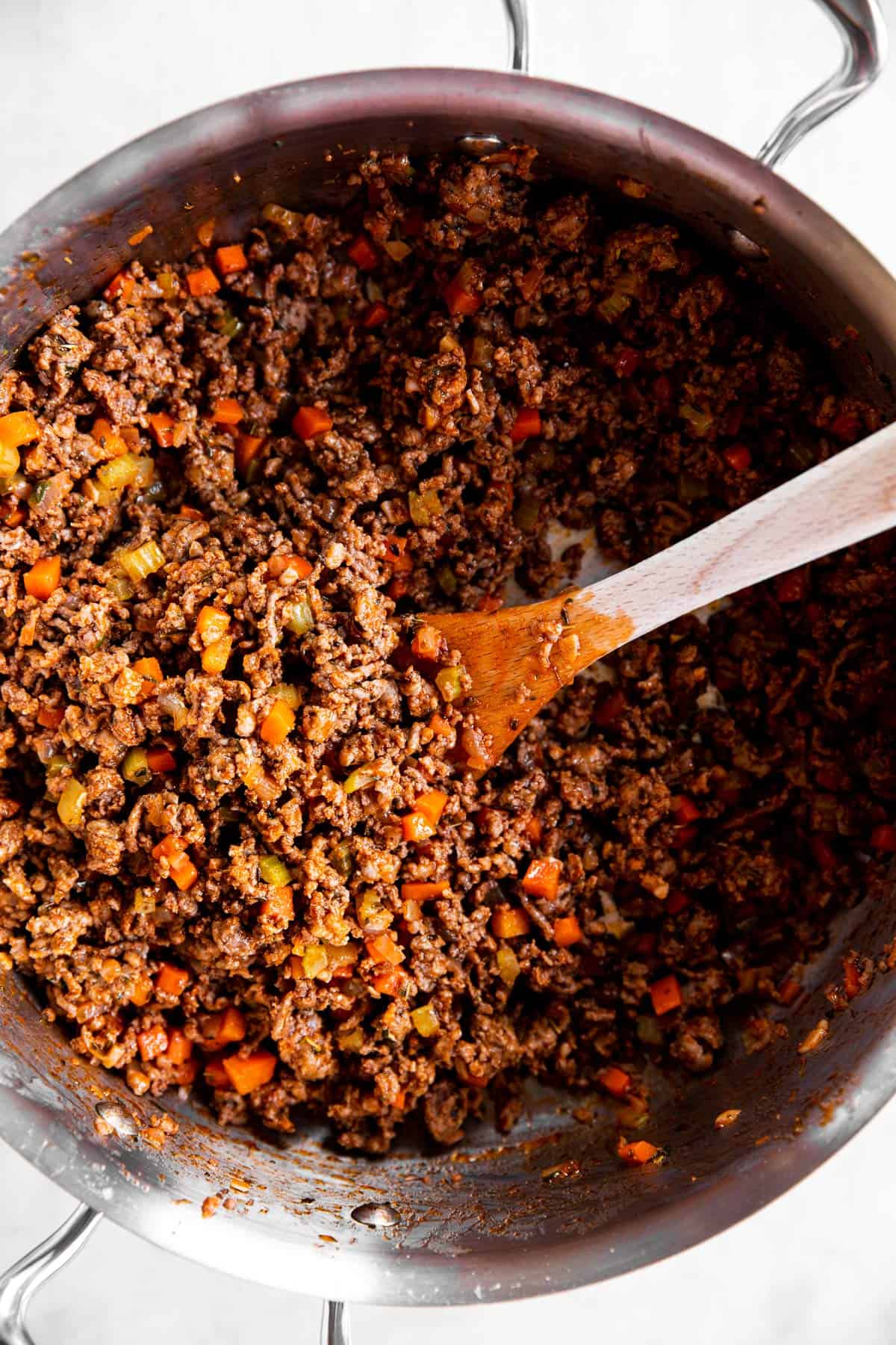 sofrito with browned ground beef in stainless steel pan