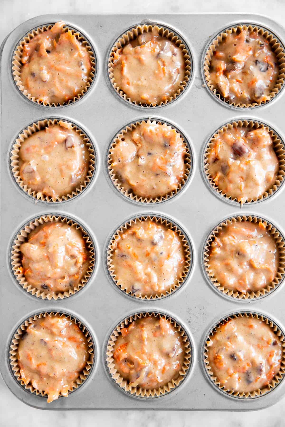 carrot muffin batter divided between 12 lined muffin cups