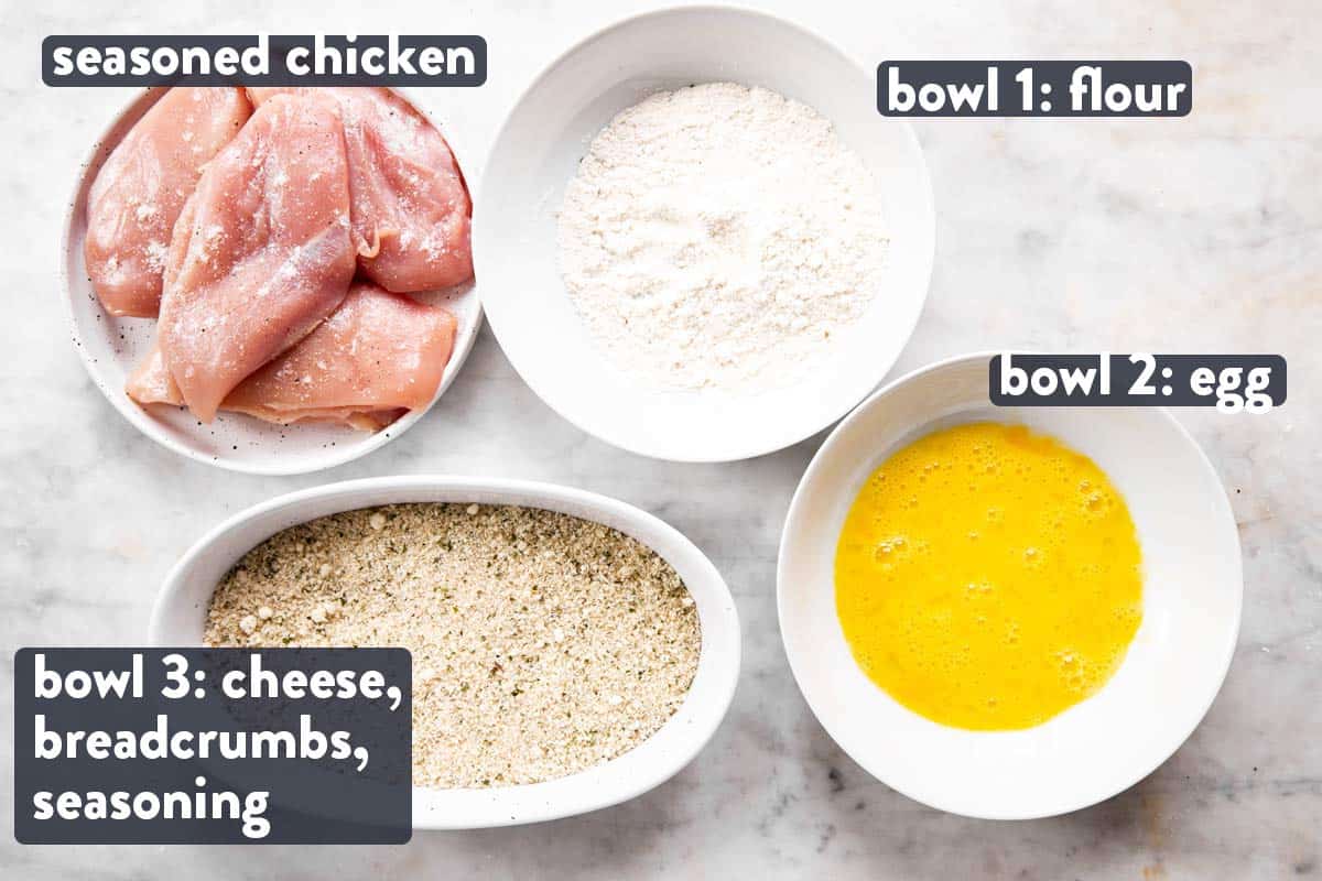 chicken breast with bowls containing ingredients for breading