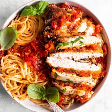 sliced thicken parmesan on top of pasta