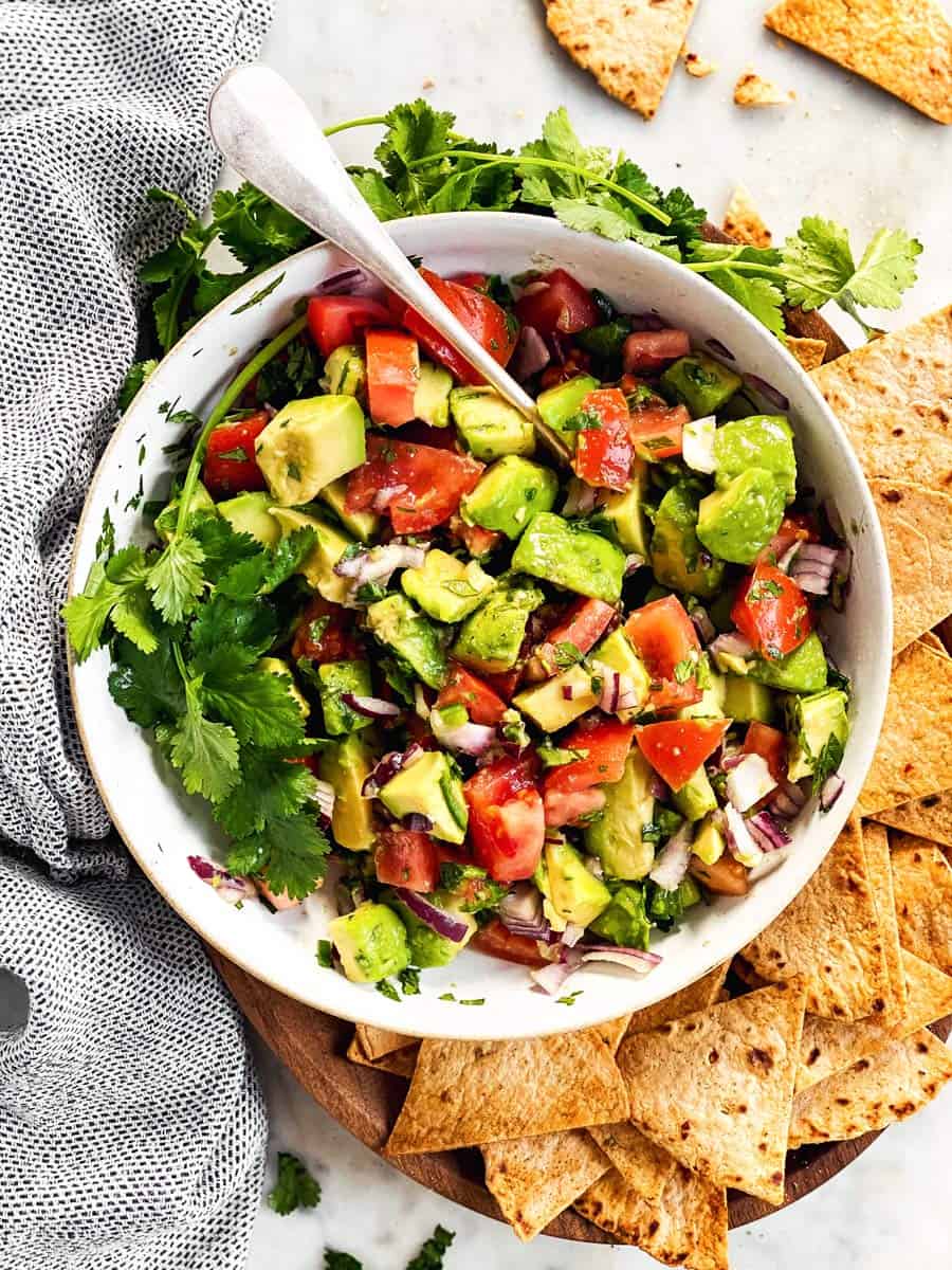 overhead image of white bowl filled with chunky avocado salsa