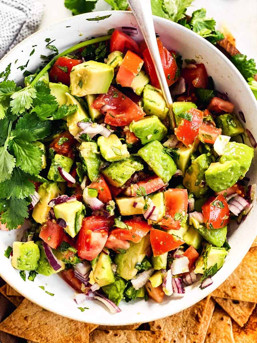 close up photo of avocado salsa in white bowl