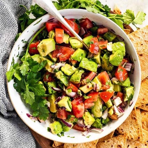 overhead image of white bowl filled with chunky avocado salsa