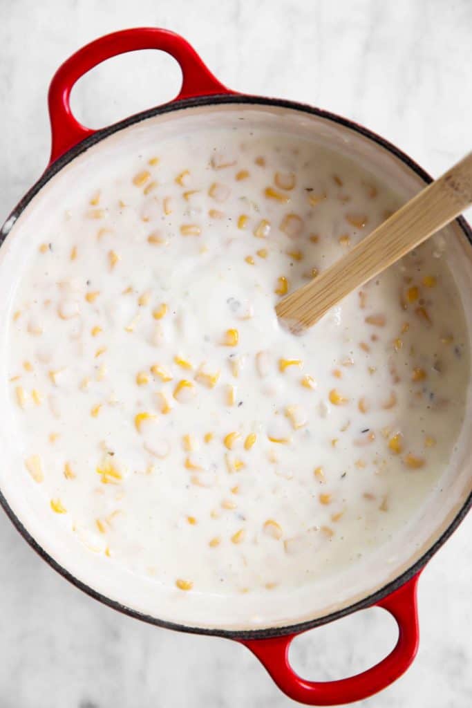 corn stirred into Béchamel sauce in Dutch oven