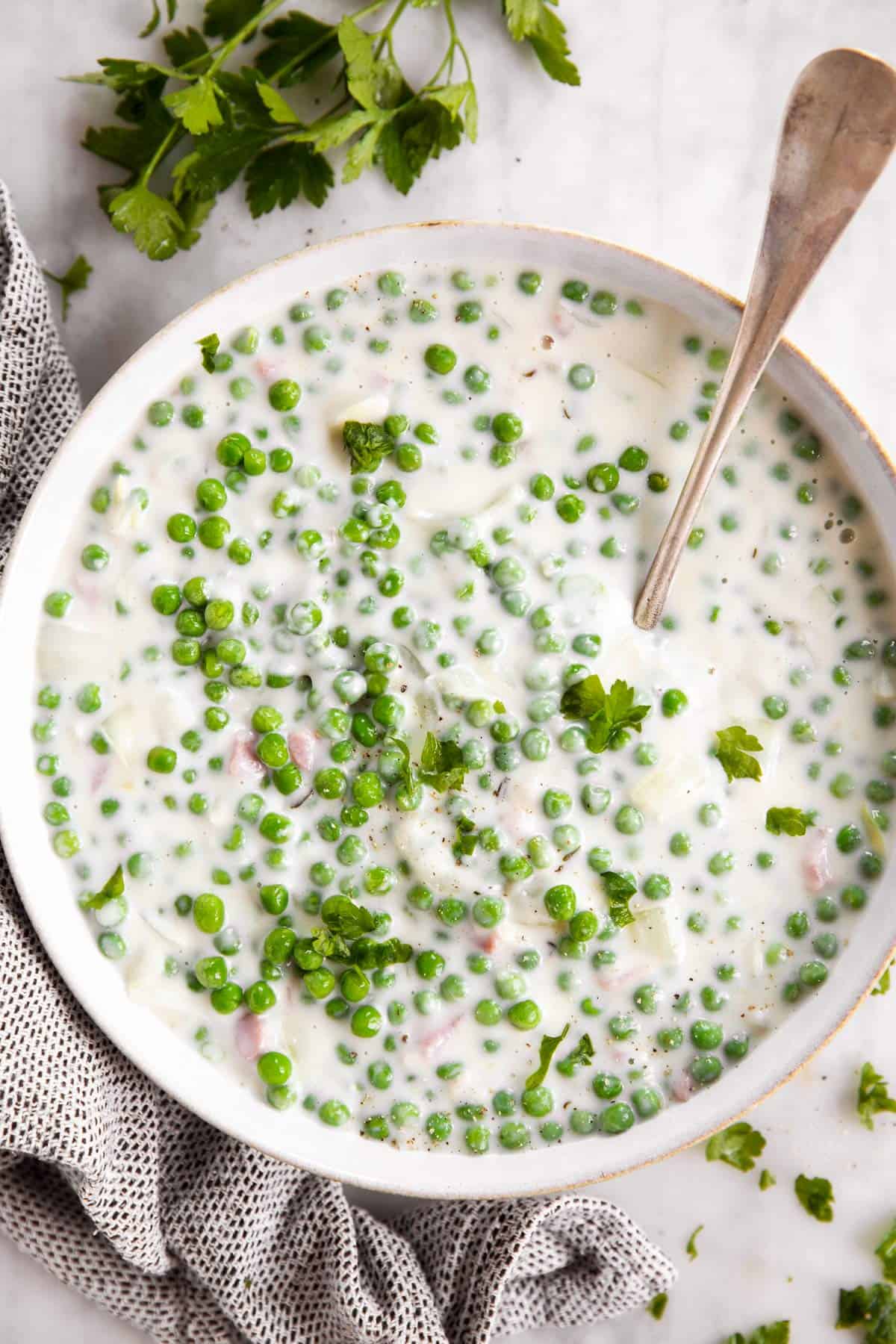 overhead view of creamed peas in white bowl