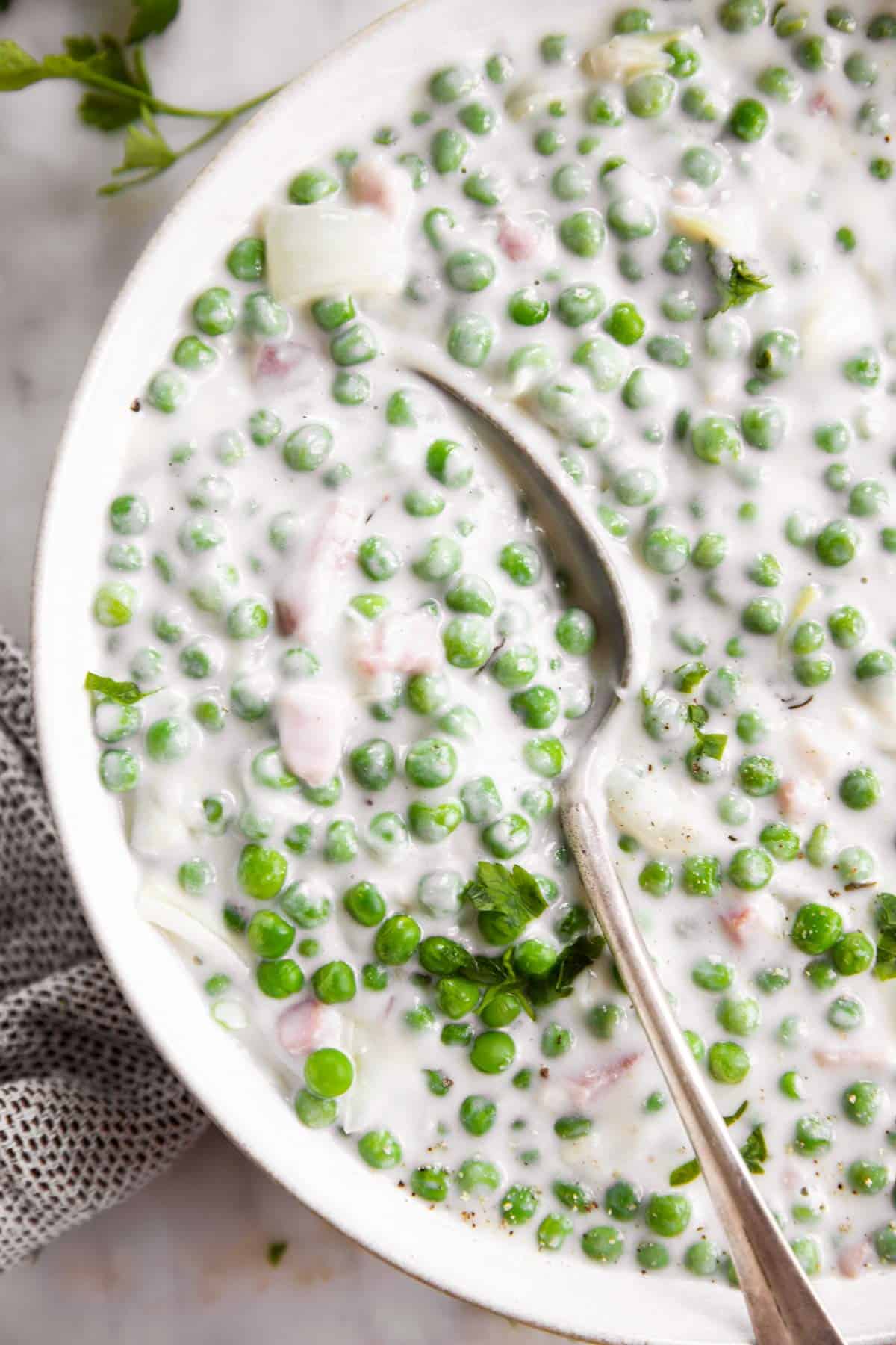 close up view of spoon in bowl with creamed peas