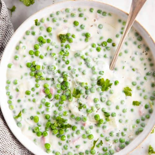 overhead view of creamed peas in white bowl