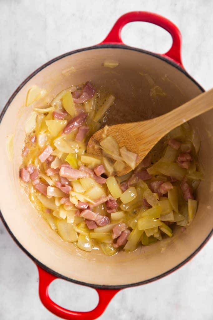 cast iron pot with sautéed onion and bacon