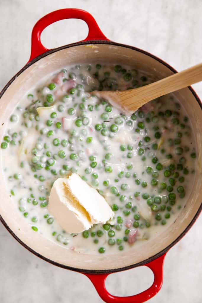 peas and cream cheese in Dutch oven with Béchamel sauce