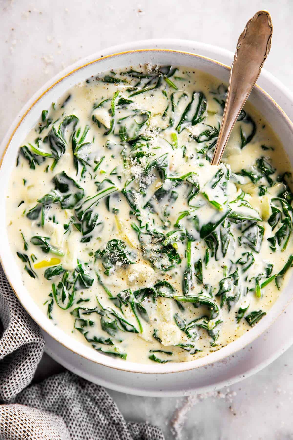 overhead view of white serving bowl filled with creamed spinach