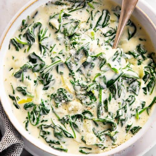 overhead view of white serving bowl filled with creamed spinach