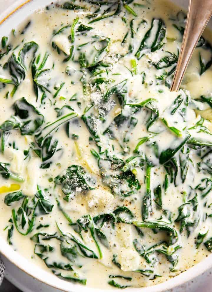 overhead view of white serving bowl filled with creamed spinach