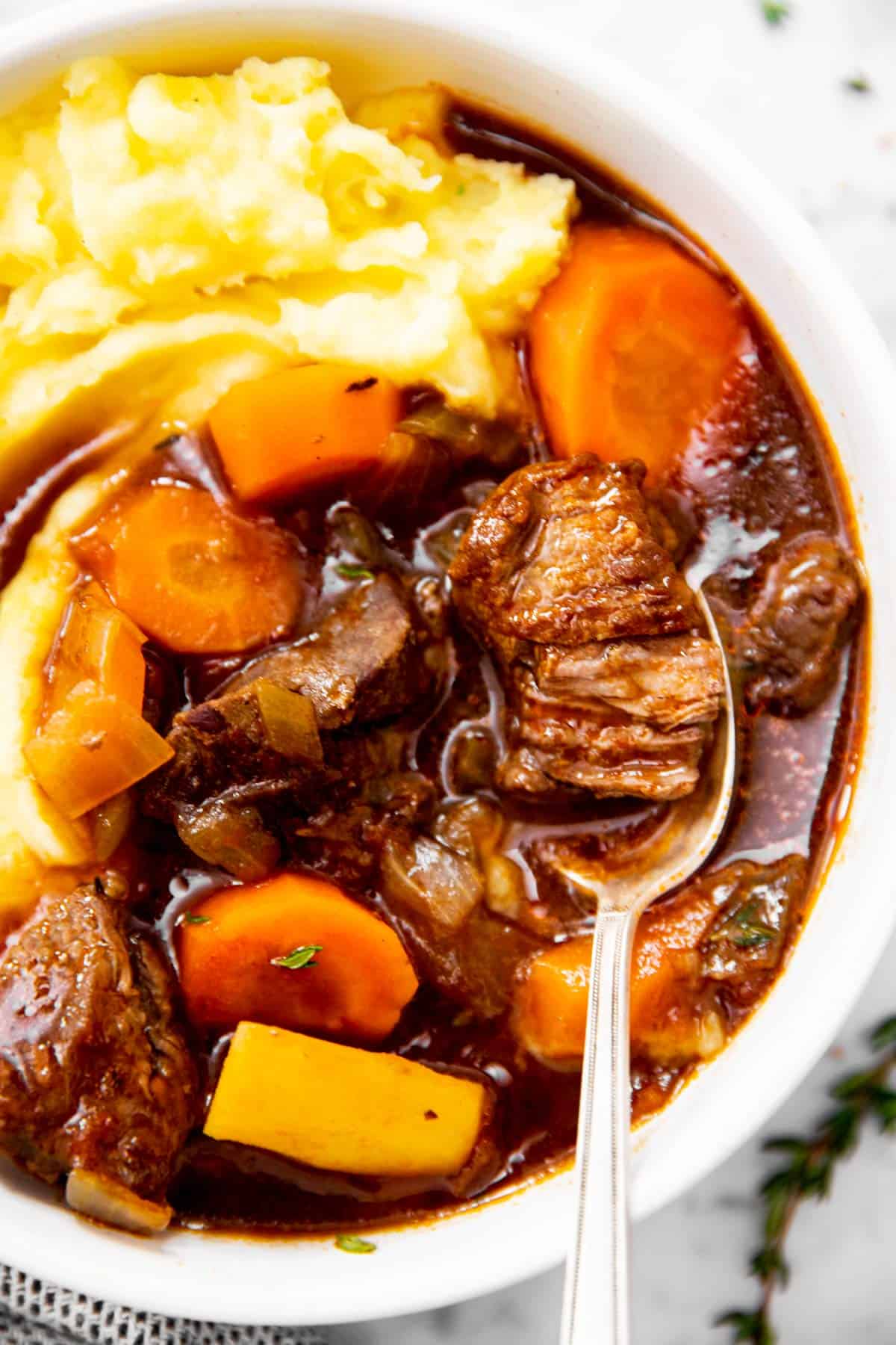 close up photo of Guinness beef stew in bowl with mashed potatoes