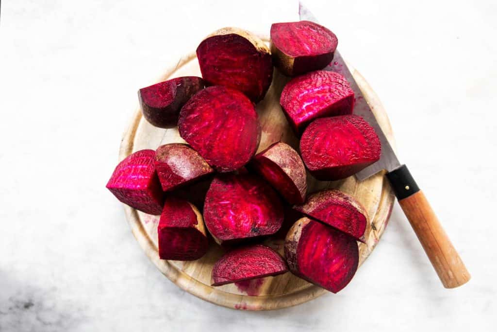 sliced beets on chopping board with knife
