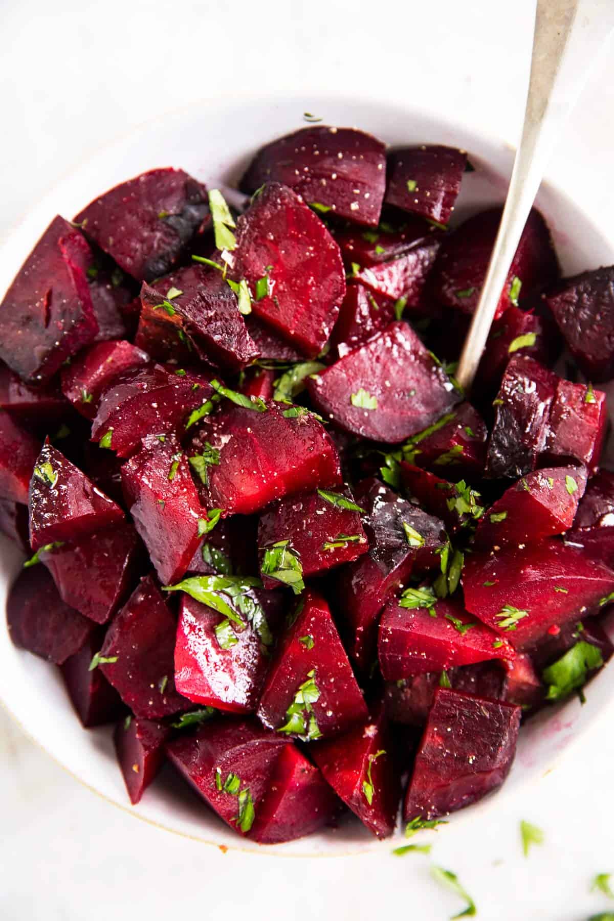 close up photo of beets in white bowl with parsley